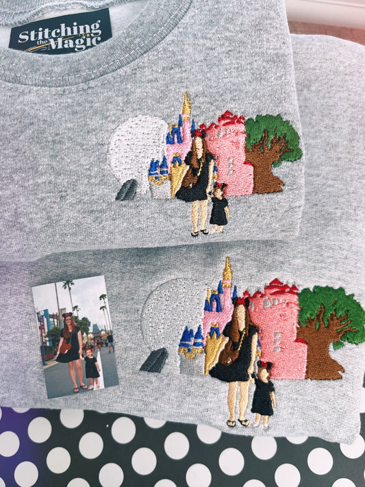 A custom embroidered sweatshirt with a design based on a photo submission, featuring a castle and two individuals.