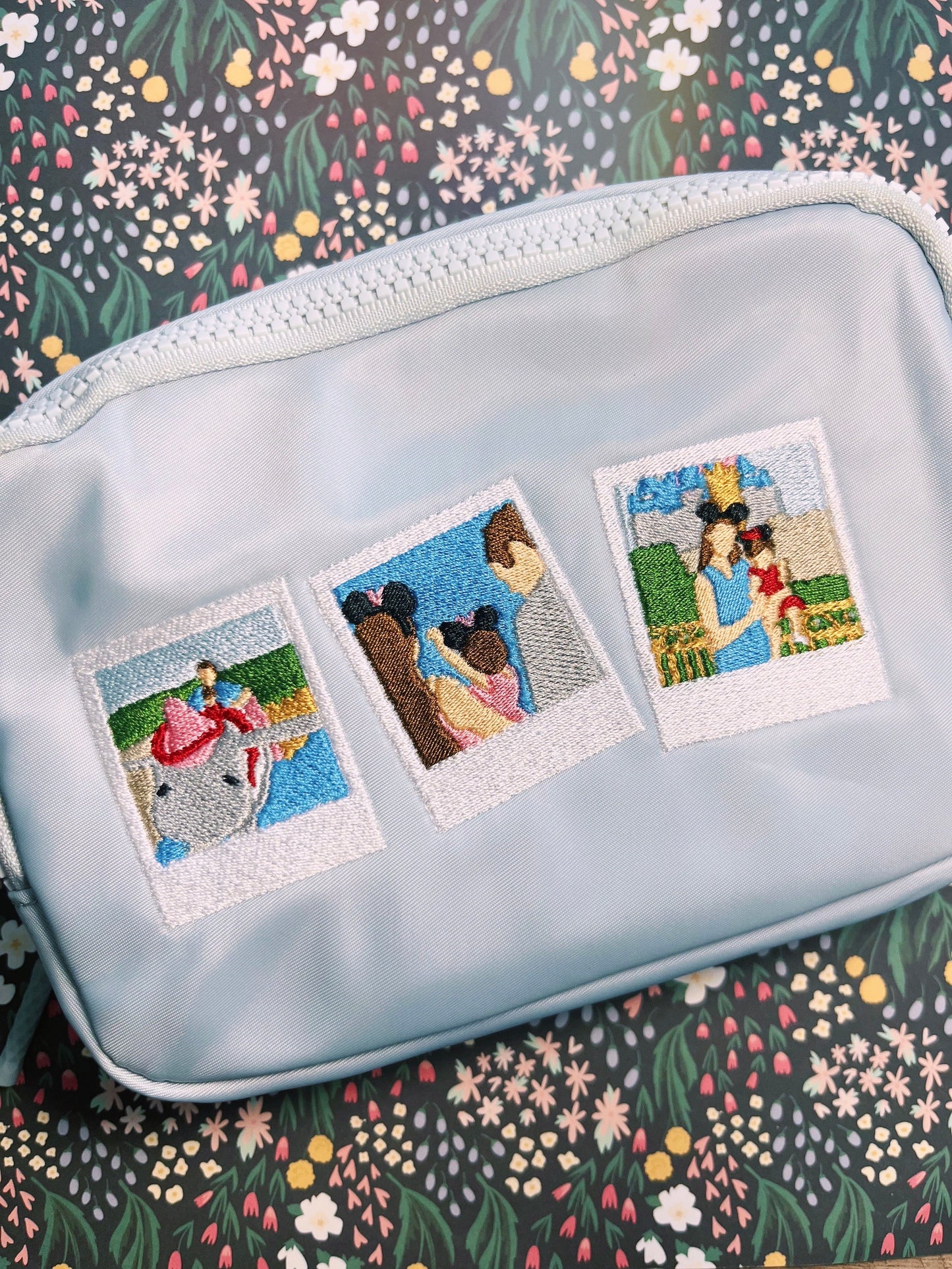 A custom embroidered blue fanny pack featuring a series of three photos with characters and a character silhouette.