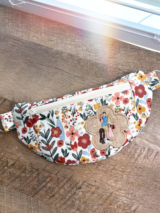 Floral patterned crossbody bag on a wooden table.