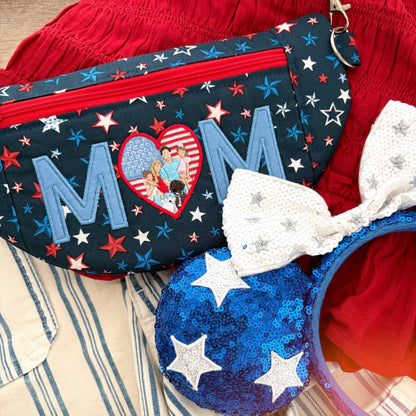 Red shirt and striped shorts in the background with character headband and star crossbody bag with MOM embroidered. 