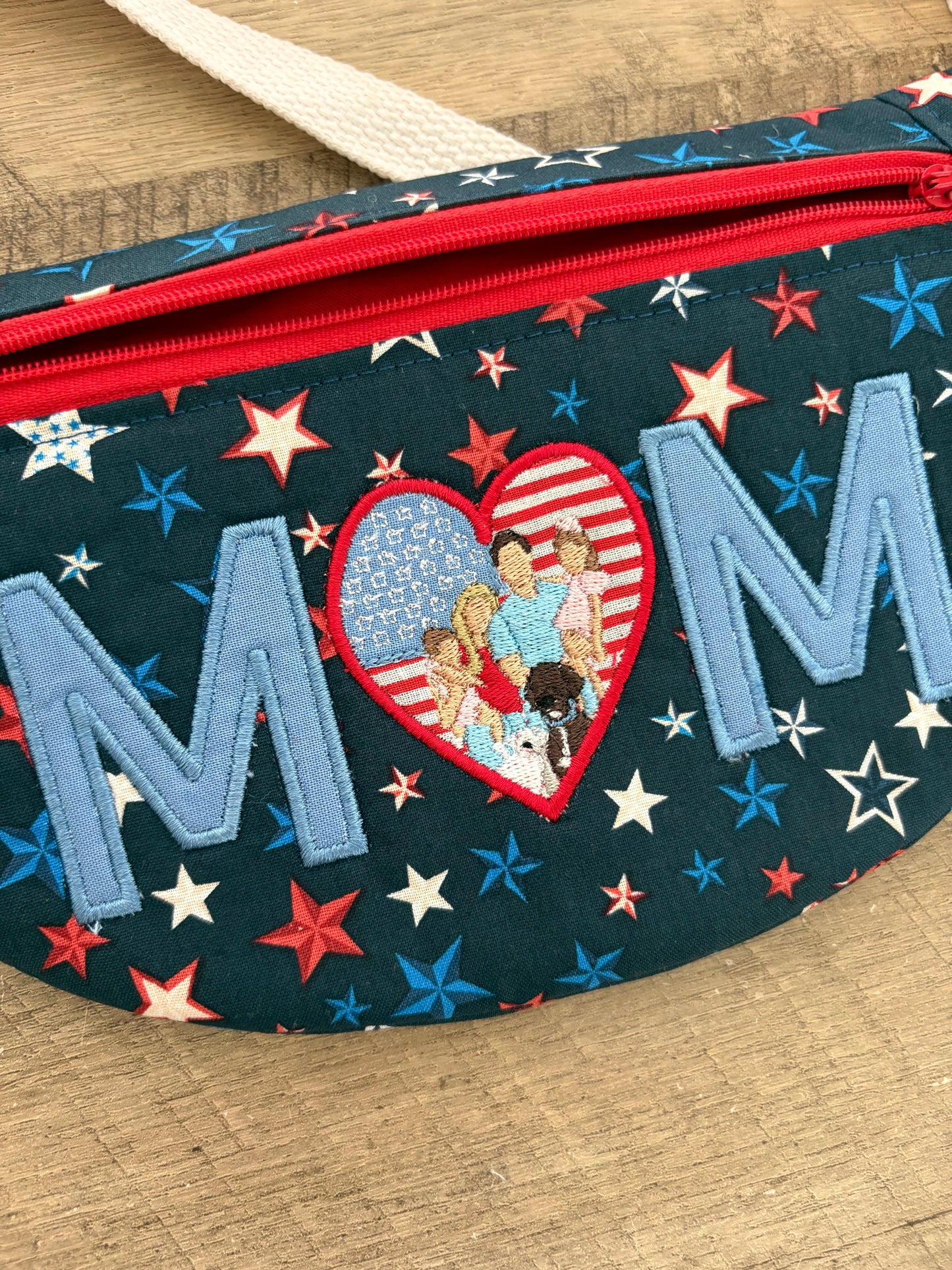 Crossbody bag with patriotic star fabric and “MOM” embroidered with a portrait. 