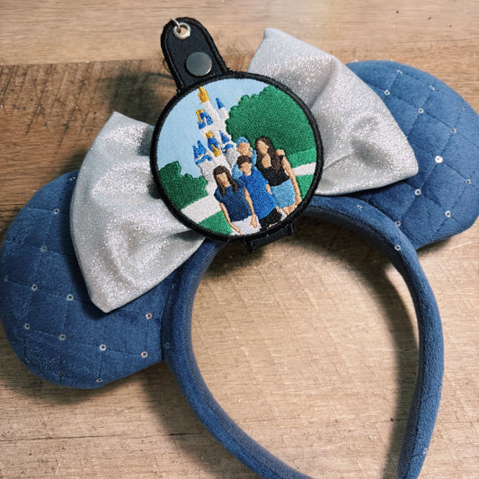 Blue mouse ears with a personalized photo charm on a wooden surface