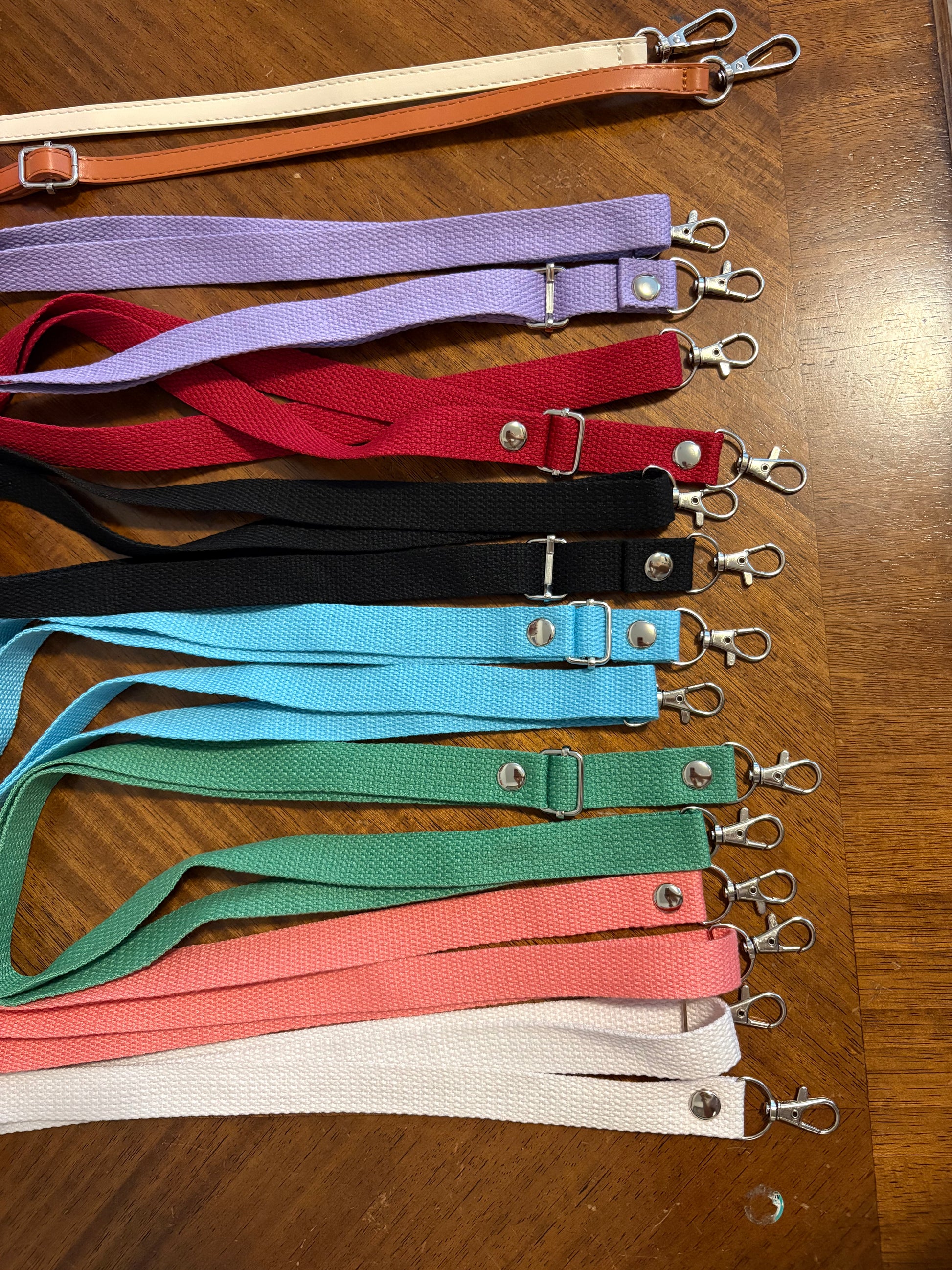 Set of colorful lanyards with metal clips on a wooden surface
