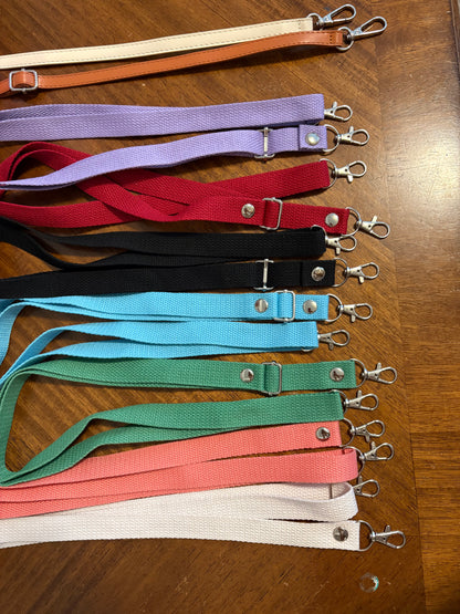 Set of colorful lanyards with metal clips on a wooden surface