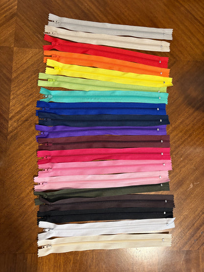 Set of colorful zippers arranged in a grid on a wooden surface