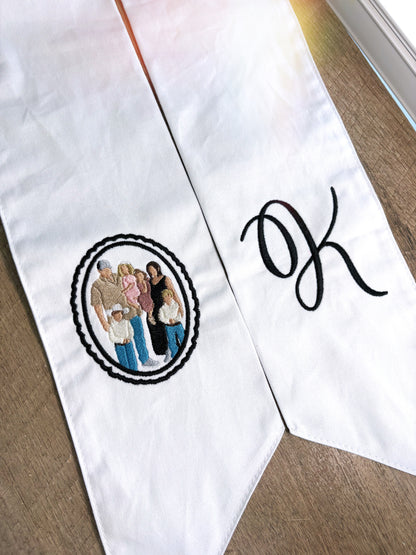 White sashes with embroidered design and letter 'K' on a wooden surface