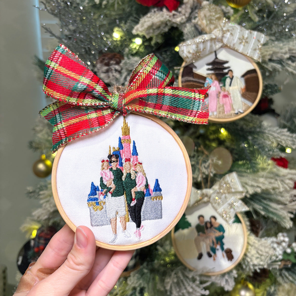 Christmas tree background with three custom embroidered ornaments on it,