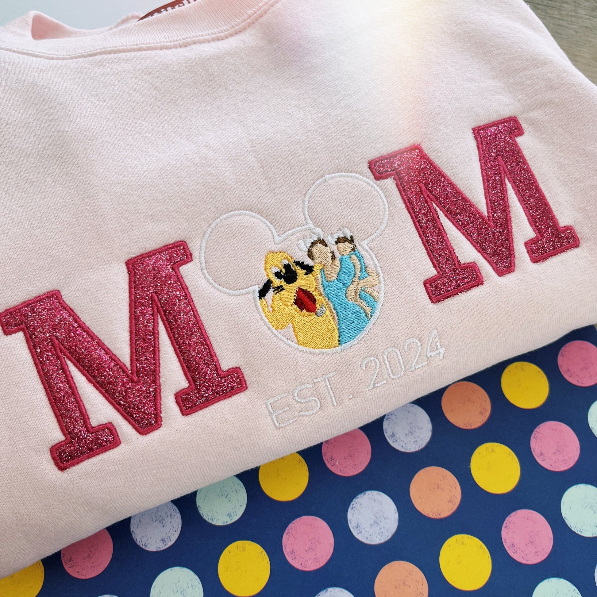 Sweatshirt with 'MOM' and cartoon character design on a polka dot background